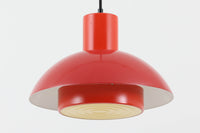 Fog & Morup(フォグ&モーラップ)社より、Jo Hammerborg(ヨー・ハーマボー)によってデザインされた「Lakaj」ペンダントライトです。直径34cmのシェードは、赤の外装と内側のホワイト&ボトムカバーの淡いイエローの配色が美しい光を柔らかく拡散し、空間に温もりと視覚的なアクセントを与えます。点灯時にはシェード上部から漏れる光が間接照明としても機能し、北欧ビンテージ家具と調和する洗練された雰囲気を演出します。ダイニングやリビングの照明に最適な、希少性と機能美を兼ね備えた一灯です。