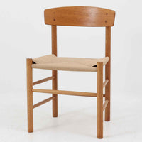 デンマークを代表するデザイナー、Borge MogensenによってFDBのためにデザインされたJ39チェアは、オーク材の丸脚と座面に丁寧に編み込まれたペーパーコードが特徴の、素朴ながらも完成度の高い北欧ビンテージチェアです。農村のキッチンチェアをルーツに持つそのデザインは、無駄を省いた潔い構造と機能美が融合し、空間に凛とした佇まいをもたらします。ダイニングはもちろん、ワークチェアやアクセントチェアとしても重宝する一脚です。