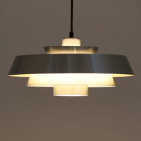 Jo Hammerborgがデザインし、Fog & Morup社から発表されたペンダントライト「Nova」です。アルミを用いた精緻なシェード構造が特徴で、直径40cmのサイズはダイニングやリビングの照明に適しています。重なり合うシェードが光を柔らかく拡散し、眩しさを抑えながら温かみのある空間を演出。シルバーの質感と洗練されたフォルムは、モダンでありながら北欧デザインらしい静かな存在感を放ちます。ビンテージならではの希少性に加え、素材の経年変化が加わることで、光とともに独特の風合いを楽しめる逸品です。