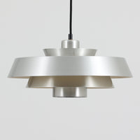 Jo Hammerborgがデザインし、Fog & Morup社から発表されたペンダントライト「Nova」です。アルミを用いた精緻なシェード構造が特徴で、直径40cmのサイズはダイニングやリビングの照明に適しています。重なり合うシェードが光を柔らかく拡散し、眩しさを抑えながら温かみのある空間を演出。シルバーの質感と洗練されたフォルムは、モダンでありながら北欧デザインらしい静かな存在感を放ちます。ビンテージならではの希少性に加え、素材の経年変化が加わることで、光とともに独特の風合いを楽しめる逸品です。