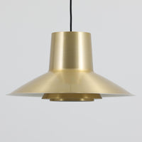 Svend Middelboeがデザインし、Nordisk Solar社より発表されたペンダントライト「Auditorie」です。直径49cmの大ぶりなサイズと、アルミ素材に施された美しい真鍮色の仕上げが特徴で、点灯時には下方向に効率よく光を届けつつ、柔らかく反射する光が空間を上品に彩ります。大胆なフォルムながらもバランスの取れたデザインは、1960年代北欧モダンのエッセンスを凝縮しており、ダイニングやリビングの主照明として存在感を放ちます。経年により深みを増した表情はビンテージならではの魅力で、機能性と美しさを兼ね備えた希少な一灯です。