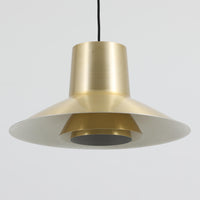 Svend Middelboeがデザインし、Nordisk Solar社より発表されたペンダントライト「Auditorie」です。直径49cmの大ぶりなサイズと、アルミ素材に施された美しい真鍮色の仕上げが特徴で、点灯時には下方向に効率よく光を届けつつ、柔らかく反射する光が空間を上品に彩ります。大胆なフォルムながらもバランスの取れたデザインは、1960年代北欧モダンのエッセンスを凝縮しており、ダイニングやリビングの主照明として存在感を放ちます。経年により深みを増した表情はビンテージならではの魅力で、機能性と美しさを兼ね備えた希少な一灯です。