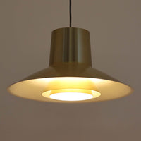 Svend Middelboeがデザインし、Nordisk Solar社より発表されたペンダントライト「Auditorie」です。直径49cmの大ぶりなサイズと、アルミ素材に施された美しい真鍮色の仕上げが特徴で、点灯時には下方向に効率よく光を届けつつ、柔らかく反射する光が空間を上品に彩ります。大胆なフォルムながらもバランスの取れたデザインは、1960年代北欧モダンのエッセンスを凝縮しており、ダイニングやリビングの主照明として存在感を放ちます。経年により深みを増した表情はビンテージならではの魅力で、機能性と美しさを兼ね備えた希少な一灯です。