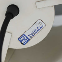 Jo HammerborgがFog & Morup社のためにデザインした「Central」ペンダントライトです。直径23cmのコンパクトなサイズながら、スチール製の二重シリンダー構造が特徴的で、点灯時には上下から光が広がり独特の陰影を演出します。外側のグレーと内側のホワイトがコントラストを生み、点灯時にはほのかなグリーンの光が漏れ出す美しいデザインです。ダイニングや小スペースに適したサイズで、北欧モダンのエッセンスを感じさせるビンテージ照明です。シェードの内側に施されたグリーンの塗装が、点灯時に柔らかなニュアンスを加え、空間に独特の雰囲気を演出します。