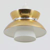 Louis Poulsen社製の小ぶりなペンダントライト「Doo-Wop」です。直径29cmの扱いやすいサイズで、真鍮カラーの上部シェードとホワイトの内側シェードのコントラストが美しいデザイン。点灯時には上下に光を広げ、空間を柔らかく照らし出します。1950年代にデンマーク海軍と共同で開発されたモデルで、シンプルながらも存在感のある佇まいが魅力です。ダイニングやキッチンに適しており、ビンテージならではの味わい深い風合いをお楽しみいただけます。さらに、現行品とは異なりシェードはマイナスネジで固定されており、当時のオリジナルならではのディテールが残されています。