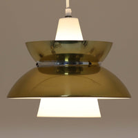 Louis Poulsen社製の小ぶりなペンダントライト「Doo-Wop」です。直径29cmの扱いやすいサイズで、真鍮カラーの上部シェードとホワイトの内側シェードのコントラストが美しいデザイン。点灯時には上下に光を広げ、空間を柔らかく照らし出します。1950年代にデンマーク海軍と共同で開発されたモデルで、シンプルながらも存在感のある佇まいが魅力です。ダイニングやキッチンに適しており、ビンテージならではの味わい深い風合いをお楽しみいただけます。さらに、現行品とは異なりシェードはマイナスネジで固定されており、当時のオリジナルならではのディテールが残されています。