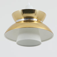 Louis Poulsen社製の小ぶりなペンダントライト「Doo-Wop」です。直径29cmの扱いやすいサイズで、真鍮カラーの上部シェードとホワイトの内側シェードのコントラストが美しいデザイン。点灯時には上下に光を広げ、空間を柔らかく照らし出します。1950年代にデンマーク海軍と共同で開発されたモデルで、シンプルながらも存在感のある佇まいが魅力です。ダイニングやキッチンに適しており、ビンテージならではの味わい深い風合いをお楽しみいただけます。さらに、現行品とは異なりシェードはマイナスネジで固定されており、当時のオリジナルならではのディテールが残されています。