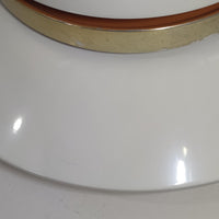 Louis Poulsen社製の小ぶりなペンダントライト「Doo-Wop」です。直径29cmの扱いやすいサイズで、真鍮カラーの上部シェードとホワイトの内側シェードのコントラストが美しいデザイン。点灯時には上下に光を広げ、空間を柔らかく照らし出します。1950年代にデンマーク海軍と共同で開発されたモデルで、シンプルながらも存在感のある佇まいが魅力です。ダイニングやキッチンに適しており、ビンテージならではの味わい深い風合いをお楽しみいただけます。さらに、現行品とは異なりシェードはマイナスネジで固定されており、当時のオリジナルならではのディテールが残されています。