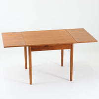 素材と構造の完成度の高さが際立つ正方形エクステンションダイニングテーブルです。天板には上質なチーク材が用いられ、木目の美しさと経年変化による深みのある色合いが北欧ビンテージらしい佇まいを演出します。普段はコンパクトな正方形として使用でき、来客時には左右の天板を引き出すことで広々としたサイズへと拡張可能な実用的な構造です。細身の脚部と幕板のバランスも良く、空間に軽やかな印象を与えます。