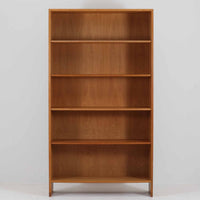 Hans J. Wegner(ハンス・J・ウェグナー)によるデザインで、Ry Mobler社から発表されたブックシェルフ「RY8」です。オーク材を用いたナチュラルな風合いと端正なラインが美しく、ウェグナーらしい機能美を感じさせます。通常モデルでは1枚が固定棚で他は可動棚となっていますが、本品は全ての棚板が取り外し可能な希少タイプで、用途に応じて高さを自在に調整できます。背面には製造年月のスタンプが残り、当時のクラフトマンシップを今に伝えています。書籍収納はもちろん、リビングやオフィスのディスプレイシェルフとしても活躍する一台です。