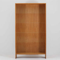 Hans J. Wegner(ハンス・J・ウェグナー)によるデザインで、Ry Mobler社から発表されたブックシェルフ「RY8」です。オーク材を用いたナチュラルな風合いと端正なラインが美しく、ウェグナーらしい機能美を感じさせます。通常モデルでは1枚が固定棚で他は可動棚となっていますが、本品は全ての棚板が取り外し可能な希少タイプで、用途に応じて高さを自在に調整できます。背面には製造年月のスタンプが残り、当時のクラフトマンシップを今に伝えています。書籍収納はもちろん、リビングやオフィスのディスプレイシェルフとしても活躍する一台です。