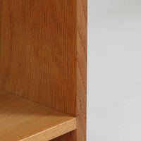 Hans J. Wegner(ハンス・J・ウェグナー)によるデザインで、Ry Mobler社から発表されたブックシェルフ「RY8」です。オーク材を用いたナチュラルな風合いと端正なラインが美しく、ウェグナーらしい機能美を感じさせます。通常モデルでは1枚が固定棚で他は可動棚となっていますが、本品は全ての棚板が取り外し可能な希少タイプで、用途に応じて高さを自在に調整できます。背面には製造年月のスタンプが残り、当時のクラフトマンシップを今に伝えています。書籍収納はもちろん、リビングやオフィスのディスプレイシェルフとしても活躍する一台です。
