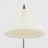 Michael Bang(マイケル・バン)によるデザインで、Le Klint(レ・クリント)から発表されたフロアランプModel 321です。高さ131cmのスチール製フレームは、無駄のない直線的なフォルムと精巧なディテールが際立ち、モダンな空間に調和します。特徴的なスライド機構によりランプの高さを調整でき、読書灯から間接照明まで幅広い用途に対応。ハンドクラフトによるプリーツシェードは柔らかい光を生み出し、北欧ビンテージならではの温もりと機能美を感じさせます。