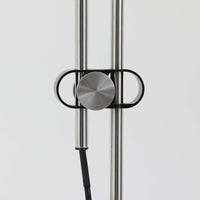 Michael Bang(マイケル・バン)によるデザインで、Le Klint(レ・クリント)から発表されたフロアランプModel 321です。高さ131cmのスチール製フレームは、無駄のない直線的なフォルムと精巧なディテールが際立ち、モダンな空間に調和します。特徴的なスライド機構によりランプの高さを調整でき、読書灯から間接照明まで幅広い用途に対応。ハンドクラフトによるプリーツシェードは柔らかい光を生み出し、北欧ビンテージならではの温もりと機能美を感じさせます。