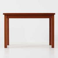 チーク材のフレームに陶磁器タイルを組み合わせたサイドテーブルは、温かみのある木肌と絵柄タイルの表情が調和した北欧ビンテージらしい一品です。天板中央に配されたタイルは、実用性に優れつつ装飾性も高く、経年による釉薬の風合いが落ち着いた存在感を演出します。直線的で端正な脚部構造は安定感があり、ソファ脇の補助台やディスプレイ台、花器やランプを置く台としても取り入れやすく、暮らしの中で静かなアクセントとなるビンテージ家具です。