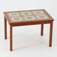 チーク材のフレームに陶磁器タイルを組み合わせたサイドテーブルは、温かみのある木肌と絵柄タイルの表情が調和した北欧ビンテージらしい一品です。天板中央に配されたタイルは、実用性に優れつつ装飾性も高く、経年による釉薬の風合いが落ち着いた存在感を演出します。直線的で端正な脚部構造は安定感があり、ソファ脇の補助台やディスプレイ台、花器やランプを置く台としても取り入れやすく、暮らしの中で静かなアクセントとなるビンテージ家具です。