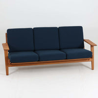 Hans J. Wegner(ハンス・J・ウェグナー)によるデザインで、Getama社から発表されたトリプルソファ「GE290」です。堅牢なオーク材フレームにボリュームのあるクッションを組み合わせた構造で、しっかりとした座り心地と安定感を実現しています。ビンテージならではのクッション内部にはスプリングが内包されており、しなやかな弾力と快適な座り心地を長く保ちます。特徴的なアームのラインや背面の格子フレームは、どの角度から見ても美しく、空間の主役となる存在感を放ちます。ブルー系ファブリックがオーク材の温もりと調和し、北欧らしい落ち着いた雰囲気を演出する名作ビンテージソファです。