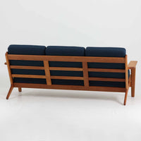Hans J. Wegner(ハンス・J・ウェグナー)によるデザインで、Getama社から発表されたトリプルソファ「GE290」です。堅牢なオーク材フレームにボリュームのあるクッションを組み合わせた構造で、しっかりとした座り心地と安定感を実現しています。ビンテージならではのクッション内部にはスプリングが内包されており、しなやかな弾力と快適な座り心地を長く保ちます。特徴的なアームのラインや背面の格子フレームは、どの角度から見ても美しく、空間の主役となる存在感を放ちます。ブルー系ファブリックがオーク材の温もりと調和し、北欧らしい落ち着いた雰囲気を演出する名作ビンテージソファです。