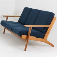 Hans J. Wegner(ハンス・J・ウェグナー)によるデザインで、Getama社から発表されたトリプルソファ「GE290」です。堅牢なオーク材フレームにボリュームのあるクッションを組み合わせた構造で、しっかりとした座り心地と安定感を実現しています。ビンテージならではのクッション内部にはスプリングが内包されており、しなやかな弾力と快適な座り心地を長く保ちます。特徴的なアームのラインや背面の格子フレームは、どの角度から見ても美しく、空間の主役となる存在感を放ちます。ブルー系ファブリックがオーク材の温もりと調和し、北欧らしい落ち着いた雰囲気を演出する名作ビンテージソファです。