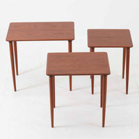 チーク材が使用されたデンマーク製のネストテーブルです。大・中・小の3台がセットになっており、入れ子式で省スペースに収納できるため状況に応じて使い分けができるのが魅力です。丸みを帯びた天板のエッジと細身ですっきりと伸びるテーパードレッグが美しいバランスでデザインされ、北欧らしい温かみのあるチークの木目が落ち着いた雰囲気を演出します。サイドテーブルや花台、来客時の補助テーブルなど多用途に活躍し、リビングに柔らかな存在感を添えてくれるビンテージアイテムです。