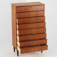 デンマーク製の8段チェストで、上質なチーク材の木目が存在感を放つ北欧ビンテージらしい一品です。細身の脚部に支えられた軽やかな佇まいと、北欧家具らしいバータイプの取っ手が、すっきりとした印象を与えます。衣類や小物をたっぷり収納でき、寝室やリビングで圧迫感なく使える点も魅力です。経年により深みを増した色艶が空間を温かく彩り、実用性と美しさを兼ね備えたチェストで、デンマークでも8段タイプは流通が少なく希少なモデルです。