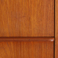 デンマーク製の8段チェストで、上質なチーク材の木目が存在感を放つ北欧ビンテージらしい一品です。細身の脚部に支えられた軽やかな佇まいと、北欧家具らしいバータイプの取っ手が、すっきりとした印象を与えます。衣類や小物をたっぷり収納でき、寝室やリビングで圧迫感なく使える点も魅力です。経年により深みを増した色艶が空間を温かく彩り、実用性と美しさを兼ね備えたチェストで、デンマークでも8段タイプは流通が少なく希少なモデルです。