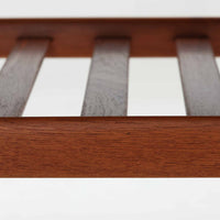 Grete Jalkがデザインし、Glostrup Mobelfabrikで製作されたこちらのセンターテーブルは、端正なプロポーションと軽やかな構造が魅力の北欧ビンテージ品です。幅160cmのゆとりある天板下にはスラット状の棚板を備え、雑誌やブランケットなどを整理しながら使える実用性も兼ね備えています。丸みを帯びた脚部や天板縁の丁寧な仕上げからは、女性デザイナーらしい繊細な美意識と当時の高い木工技術が感じられ、経年により深みを増した木肌が空間に落ち着いた存在感をもたらします。