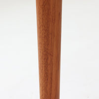 Grete Jalkがデザインし、Glostrup Mobelfabrikで製作されたこちらのセンターテーブルは、端正なプロポーションと軽やかな構造が魅力の北欧ビンテージ品です。幅160cmのゆとりある天板下にはスラット状の棚板を備え、雑誌やブランケットなどを整理しながら使える実用性も兼ね備えています。丸みを帯びた脚部や天板縁の丁寧な仕上げからは、女性デザイナーらしい繊細な美意識と当時の高い木工技術が感じられ、経年により深みを増した木肌が空間に落ち着いた存在感をもたらします。