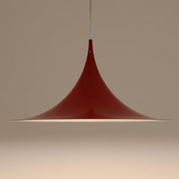 Claus Bonderup & Torsten Thorupによってデザインされ、Fog & Morup社から発表されたペンダントライト「Semi」です。直径47cmの存在感あるサイズと、シャープに絞り込まれた独特のフォルムが特徴です。鮮やかなレッドのカラーが空間にアクセントを与え、点灯時には下方向へ集中的に光を届けつつ、周囲をやわらかく照らします。1960年代に誕生したモダンデザインの象徴的な作品で、シンプルながらも彫刻的な美しさを備えています。北欧ビンテージならではの上質な佇まいで、ダイニングやリビングに華やかな雰囲気を添える一灯です。