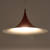 Claus Bonderup & Torsten Thorupによってデザインされ、Fog & Morup社から発表されたペンダントライト「Semi」です。直径47cmの存在感あるサイズと、シャープに絞り込まれた独特のフォルムが特徴です。鮮やかなレッドのカラーが空間にアクセントを与え、点灯時には下方向へ集中的に光を届けつつ、周囲をやわらかく照らします。1960年代に誕生したモダンデザインの象徴的な作品で、シンプルながらも彫刻的な美しさを備えています。北欧ビンテージならではの上質な佇まいで、ダイニングやリビングに華やかな雰囲気を添える一灯です。