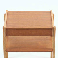 AB Carlstrom&CO Mobelfabrik社製のサイドチェストは、チーク材とオーク材を組み合わせた北欧ビンテージ家具です。温かみのあるチークの引き出し前板と、明るいオークのフレームが美しいコントラストを生み出し、軽やかで洗練された印象を与えます。上段には小物収納に便利な引き出し、下段にはオープンシェルフを備え、実用性とデザイン性を両立。幅46cmとコンパクトなサイズ感は、ベッドサイドやソファ横でのサイドテーブルとしても最適で、限られたスペースにも収まりやすい設計です。シンプルながら素材の質感と北欧家具ならではの職人技が息づく一台で、空間に温もりと個性を添えてくれます。