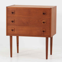 デンマーク製のチーク材を使用した3段チェストです。コンパクトな幅62cmのサイズ感ながら、3杯の引き出しを備え収納力に優れており、リビングや寝室、玄関先など幅広いシーンで活躍します。スクエア型の取っ手は彫り込みデザインで指掛かりが良く、シンプルながらも北欧家具らしい温もりと実用性を感じさせます。経年により深みを増したチーク材の色合いが、空間に落ち着きと上質な雰囲気をもたらし、ビンテージならではの魅力を楽しめる一台です。