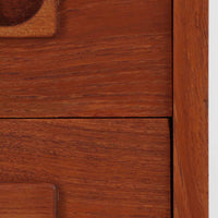 デンマーク製のチーク材を使用した3段チェストです。コンパクトな幅62cmのサイズ感ながら、3杯の引き出しを備え収納力に優れており、リビングや寝室、玄関先など幅広いシーンで活躍します。スクエア型の取っ手は彫り込みデザインで指掛かりが良く、シンプルながらも北欧家具らしい温もりと実用性を感じさせます。経年により深みを増したチーク材の色合いが、空間に落ち着きと上質な雰囲気をもたらし、ビンテージならではの魅力を楽しめる一台です。