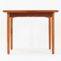 北欧らしい実用性と素材の良さが感じられる正方形エクステンションテーブルです。天板には良質なチーク材が用いられ、赤みのある木目と滑らかな手触りが、経年変化による深みとともに味わいを増しています。通常時はコンパクトなサイズ感で使いやすく、左右の補助天板を引き出すことで来客時や食事人数に応じて柔軟に対応できる構造です。脚部は細身で圧迫感がなく、幕板の緩やかな曲線が全体にやわらかな印象を与え、ダイニングはもちろんワークテーブルとしてもおすすめです。