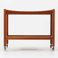 Hans J. Wegnerがデザインし、Andreas Tuck社より製造されたキャスターワゴン「AT45」は、チーク材の豊かな表情と機能美が融合した北欧ビンテージの逸品です。両サイドには持ち運びに便利な取っ手が付き、脚先にはスムーズに動くキャスターを備えているため、サービングや配膳台として活躍します。緩やかな曲線を描くフレームと丁寧な仕上げに、ウェグナーらしい美意識が宿る一台です。