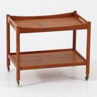 Hans J. Wegnerがデザインし、Andreas Tuck社より製造されたキャスターワゴン「AT45」は、チーク材の豊かな表情と機能美が融合した北欧ビンテージの逸品です。両サイドには持ち運びに便利な取っ手が付き、脚先にはスムーズに動くキャスターを備えているため、サービングや配膳台として活躍します。緩やかな曲線を描くフレームと丁寧な仕上げに、ウェグナーらしい美意識が宿る一台です。