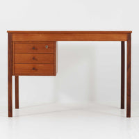 デンマーク製の片袖デスクは、北欧ビンテージ家具らしい端正な佇まいが魅力です。チーク材を用いた温かみのある色合いと、美しい木目が空間に上質な雰囲気を添えます。幅104cmとコンパクトなサイズ感でありながら、左側に3杯の引き出しを備え、上段は鍵付きで大切な書類や小物を安心して収納可能。シンプルながら堅牢な造りと細部まで行き届いた職人技が感じられ、長年の使用にも耐えうる実用性を兼ね備えています。ワークデスクや書斎机としてはもちろん、リビングや寝室に置いても自然に馴染み、北欧家具ならではの温もりと機能美を楽しめる一台です。