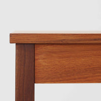 デンマーク製の片袖デスクは、北欧ビンテージ家具らしい端正な佇まいが魅力です。チーク材を用いた温かみのある色合いと、美しい木目が空間に上質な雰囲気を添えます。幅104cmとコンパクトなサイズ感でありながら、左側に3杯の引き出しを備え、上段は鍵付きで大切な書類や小物を安心して収納可能。シンプルながら堅牢な造りと細部まで行き届いた職人技が感じられ、長年の使用にも耐えうる実用性を兼ね備えています。ワークデスクや書斎机としてはもちろん、リビングや寝室に置いても自然に馴染み、北欧家具ならではの温もりと機能美を楽しめる一台です。