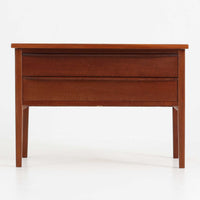 デンマーク製2段チェストです。無駄のないシンプルなフォルムとチーク材特有の深みのある色合いが美しく、北欧らしい上品な佇まいを感じさせます。引き出しの前板にはデンマーク家具らしい取手が施され、素材の質感を引き立てるデザインです。上段には仕切りが設けられており、小物の整理にも便利です。コンパクトなサイズながら収納力があり、リビングやベッドサイドなど幅広いシーンで活躍します。経年により艶を増した木肌が空間に温もりを添える一品です。