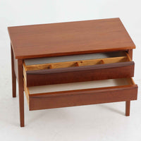 デンマーク製2段チェストです。無駄のないシンプルなフォルムとチーク材特有の深みのある色合いが美しく、北欧らしい上品な佇まいを感じさせます。引き出しの前板にはデンマーク家具らしい取手が施され、素材の質感を引き立てるデザインです。上段には仕切りが設けられており、小物の整理にも便利です。コンパクトなサイズながら収納力があり、リビングやベッドサイドなど幅広いシーンで活躍します。経年により艶を増した木肌が空間に温もりを添える一品です。