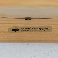 Hans J. Wegnerが1975年にデザインし、PP Mobler社が製造したPP52 Captain's Chairは、背からアームまで滑らかにつながる一体成型の美しいフォルムが魅力のアームチェアです。素材には木目の美しいアッシュ材と本革が用いられ、背面には象徴的な埋木の意匠が施されています。座面はゆったりとしたカーブで快適な座り心地を実現し、ダイニングからデスクシーンまで幅広く対応します。現在も製造されており、現行品の販売価格は約90~100万円程度となっています。