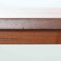 Henning Kjaernulf(ヘニング・ケアヌルフ)によるデザイン、Vejle Stole og Mobelfabrik社製のセンターテーブルです。チーク材特有の深みある色合いと美しい木目が際立ち、北欧家具らしい上質な雰囲気を漂わせます。脚部から幕板にかけての滑らかな曲線が職人技を感じさせ、どの角度から見ても整った美しいフォルムが魅力です。リビングの中心で穏やかな存在感を放ち、ソファとの相性も抜群。経年により増した艶が、ビンテージ家具ならではの温もりを感じさせます。なお、天板や幕板はチーク材と思われ、脚部にはチークに近い色調と質感をもつアフロモシア材が使用されている可能性があります。