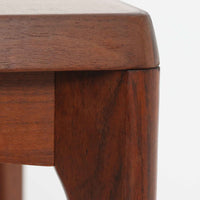 Henning Kjaernulf(ヘニング・ケアヌルフ)によるデザイン、Vejle Stole og Mobelfabrik社製のセンターテーブルです。チーク材特有の深みある色合いと美しい木目が際立ち、北欧家具らしい上質な雰囲気を漂わせます。脚部から幕板にかけての滑らかな曲線が職人技を感じさせ、どの角度から見ても整った美しいフォルムが魅力です。リビングの中心で穏やかな存在感を放ち、ソファとの相性も抜群。経年により増した艶が、ビンテージ家具ならではの温もりを感じさせます。なお、天板や幕板はチーク材と思われ、脚部にはチークに近い色調と質感をもつアフロモシア材が使用されている可能性があります。