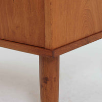 デンマーク製のチーク材3段チェストです。前板の一体的なデザインが美しく、取手部分を削り出した滑らかなラインが上品な印象を与えます。幅が77cmと少し大きめで、コンパクトながら収納力があり、寝室や玄関、リビングのサイド収納としても活躍します。最上段には鍵付きの引き出しが設けられ、大切な書類や貴重品の保管にも便利です。脚部まで丁寧に仕上げられた造りは北欧家具ならではの職人技を感じさせ、空間に温もりを添えてくれます。