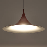 Claus Bonderup & Torsten Thorupによってデザインされ、Fog & Morup社から発表されたペンダントライト「Semi」です。直径47cmの存在感あるサイズと、シャープに絞り込まれた独特のフォルムが特徴です。鮮やかなレッドのカラーが空間にアクセントを与え、点灯時には下方向へ集中的に光を届けつつ、周囲をやわらかく照らします。1960年代に誕生したモダンデザインの象徴的な作品で、シンプルながらも彫刻的な美しさを備えています。北欧ビンテージならではの上質な佇まいで、ダイニングやリビングに華やかな雰囲気を添える一灯です。