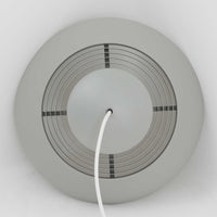 Arne JacobsenがLouis Poulsenのためにデザインした「AJ Royal 370」ペンダントライトです。直径37cmのサイズで、段階的に重なる上部シェードと、下面を覆うアクリルディフューザーによって光が柔らかく拡散し、均一で心地よい明かりを提供します。アルミとスチールの堅牢な構造に加え、シンプルかつモダンなフォルムが空間に洗練された印象を与えます。ダイニングやリビングに適した存在感ある照明で、北欧デザインを象徴するビンテージアイテムです。現行モデルでは展開されていないライトグレーのカラーは、当時のオリジナル品ならではの希少な仕様であり、コレクターズアイテムとしても高い価値を持っています。