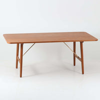 Borge Mogensenがデザインし、Soborg Mobler社より製造されたダイニングテーブル「BM1160」ハンティングテーブルです。現行品はカール・ハンセン社からも展開されていますが、こちらはSoborg社製造によるビンテージ品で、現在では入手が難しいチーク材仕様となっています。幅180cmと現行品よりややコンパクトなサイズ感で、日本の住空間にも取り入れやすい設計です。豊かな木目を持つチーク材の天板に、脚部を支える真鍮製クロスバーを組み合わせることで、堅牢さと美しさを兼ね備えています。角には滑らかな曲線が施され、温かみのある印象を添えつつ、家族や来客を迎える食卓として十分な広さを誇ります。真鍮パーツは構造的強度を高めると同時にビンテージらしい上質なアクセントとなり、シンプルでありながら存在感ある佇まいを演出。北欧家具ならではの実用性とデザイン性が息づき、年月を重ねることでさらに素材の風合いが深まり、空間を豊かに彩ります。