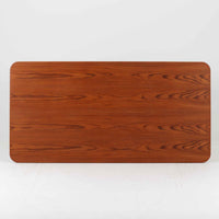 Borge Mogensenがデザインし、Soborg Mobler社より製造されたダイニングテーブル「BM1160」ハンティングテーブルです。現行品はカール・ハンセン社からも展開されていますが、こちらはSoborg社製造によるビンテージ品で、現在では入手が難しいチーク材仕様となっています。幅180cmと現行品よりややコンパクトなサイズ感で、日本の住空間にも取り入れやすい設計です。豊かな木目を持つチーク材の天板に、脚部を支える真鍮製クロスバーを組み合わせることで、堅牢さと美しさを兼ね備えています。角には滑らかな曲線が施され、温かみのある印象を添えつつ、家族や来客を迎える食卓として十分な広さを誇ります。真鍮パーツは構造的強度を高めると同時にビンテージらしい上質なアクセントとなり、シンプルでありながら存在感ある佇まいを演出。北欧家具ならではの実用性とデザイン性が息づき、年月を重ねることでさらに素材の風合いが深まり、空間を豊かに彩ります。