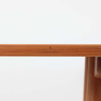 Borge Mogensenがデザインし、Soborg Mobler社より製造されたダイニングテーブル「BM1160」ハンティングテーブルです。現行品はカール・ハンセン社からも展開されていますが、こちらはSoborg社製造によるビンテージ品で、現在では入手が難しいチーク材仕様となっています。幅180cmと現行品よりややコンパクトなサイズ感で、日本の住空間にも取り入れやすい設計です。豊かな木目を持つチーク材の天板に、脚部を支える真鍮製クロスバーを組み合わせることで、堅牢さと美しさを兼ね備えています。角には滑らかな曲線が施され、温かみのある印象を添えつつ、家族や来客を迎える食卓として十分な広さを誇ります。真鍮パーツは構造的強度を高めると同時にビンテージらしい上質なアクセントとなり、シンプルでありながら存在感ある佇まいを演出。北欧家具ならではの実用性とデザイン性が息づき、年月を重ねることでさらに素材の風合いが深まり、空間を豊かに彩ります。