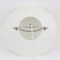 Pandul(パンドゥル)社が正規製造している、ハンス・J・ウェグナー(Hans J. Wegner)デザインのペンダントライト「JH604」です。1960年代にLouis Poulsen(ルイスポールセン)社で製造されていたモデルで、ウェグナーが自邸のためにデザインしたことでも知られています。直径50cmの存在感あるフォルムと、アルミ製シェードとステンレス製アームによる軽やかで堅牢な構造は、北欧デザインらしい機能美を体現。点灯時には下方向だけでなくシェード上部の隙間からも光が柔らかく漏れ、空間に奥行きを与えます。Pandulは1982年にデンマークで設立され、Louis Poulsenから受け継いだ名作を当時のデザインと品質を尊重して製造しているブランドです。なお、本品はプラスチック製コードリールが欠品しておりますが、全体として良好なコンディションを保っています。ヴィンテージデザインの魅力と現行製造ならではの安心感を兼ね備えた、北欧デザインを象徴する一灯です。